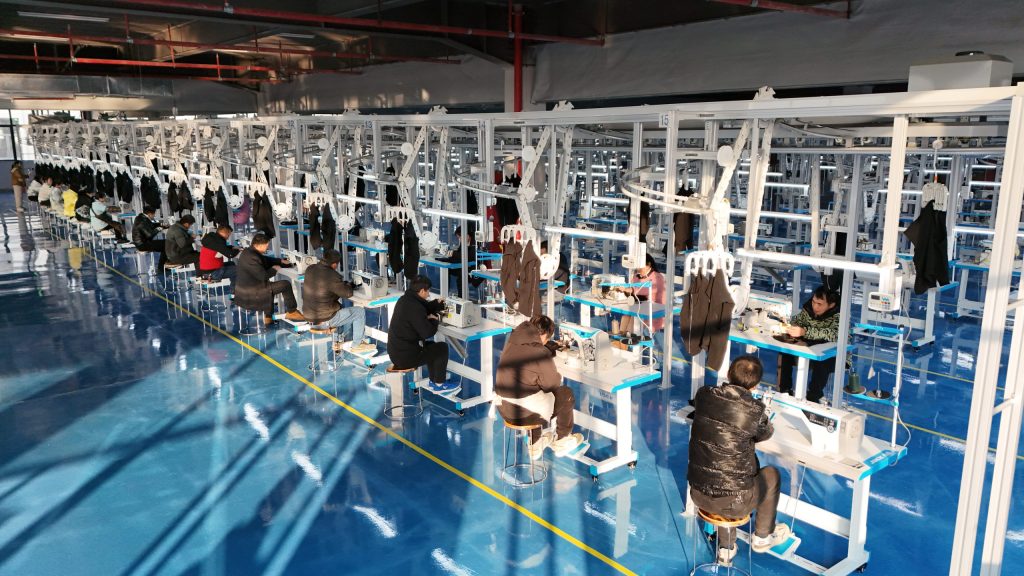 Ethical Manufacturing in Fashion - D&J Fashion’s Commitment to Sustainable Production Workers in a factory sewing garments using modern equipment and technology.