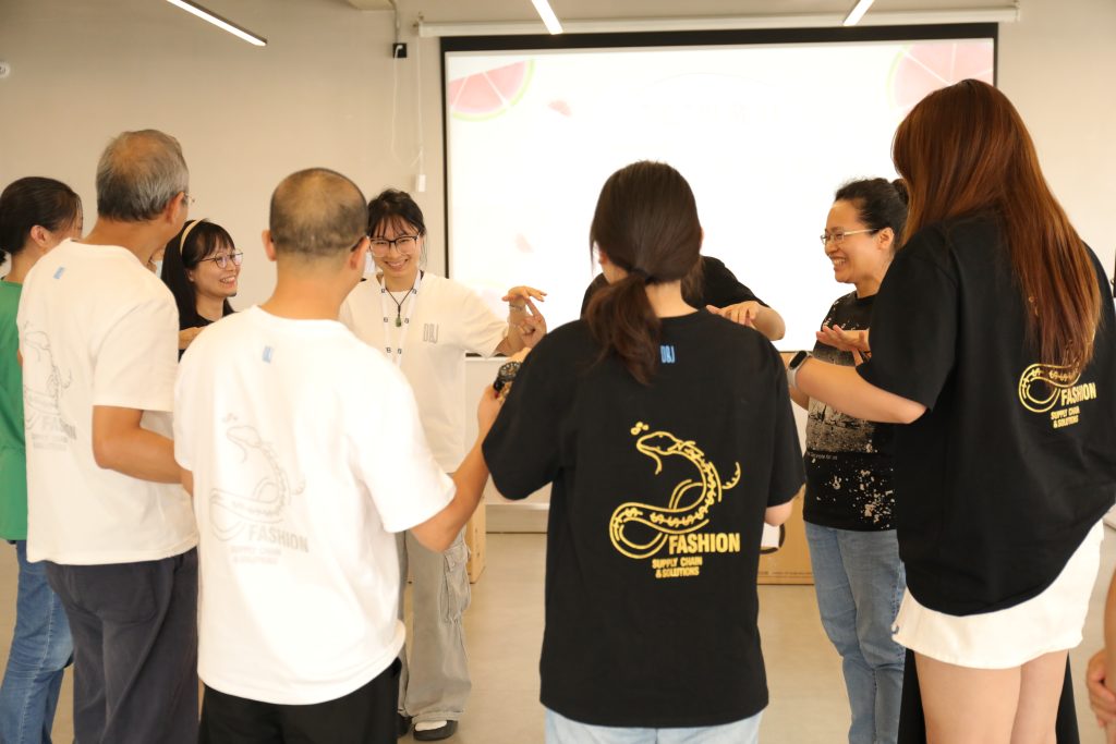 Team Building Activity at D&J Fashion’s July Birthday Celebration Employees of D&J Fashion participating in a fun team-building activity at the company’s July birthday celebration.