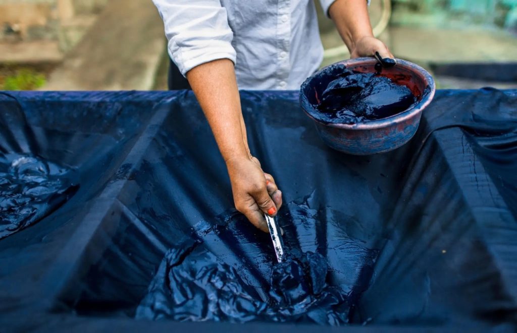 Traditional natural indigo dyeing process, supporting eco-friendly fabric production for sustainable women’s fashion.