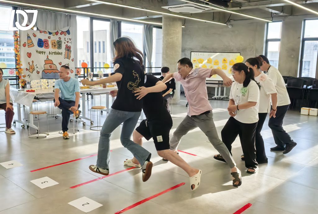 D&J Fashion Group employees playing a fun teamwork game during the September birthday celebration, enhancing collaboration