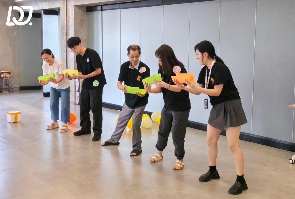 D&J Fashion Group employees participating in a fun birthday party game, showcasing teamwork and employee engagement