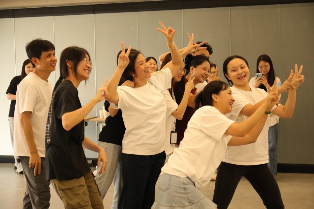 Laughter and Team Bonding at D&J Fashion’s Birthday Celebration Team members at D&J Fashion laughing and posing during the birthday event, highlighting workplace happiness and unity.